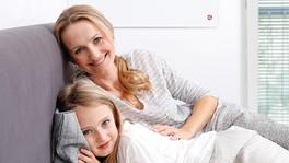 Femme et fille dans le couch et panneau infrarouge aux mur