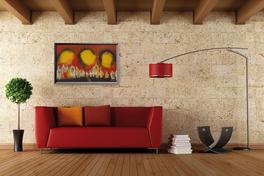 Wohnzimmer mit rotes Sofa und Bild Infrarotheizung an der Wand