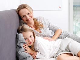 Mutter mit Kind vor Infrarotheizung Mutter mit Kind vor Infrarotheizung